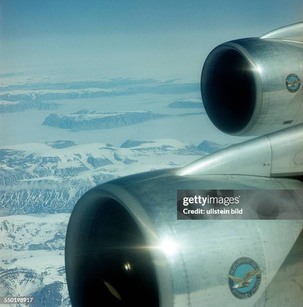 Jumbo Jet im Transatlantikflug nach Kanada über der polaren Eiswelt der Hudson Bay, vorn die beiden Düsentriebwerke des Fliegers