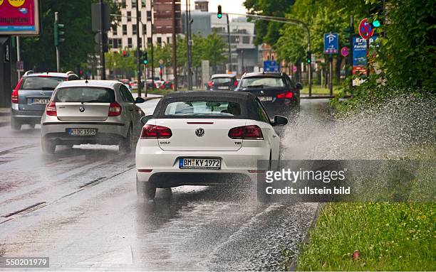 Autos im Regen, durch stehendes Wasser am Straßenrand erhöhte Aquaplaninggefahr