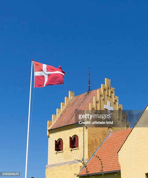 Church in Allinge-Sandvig on Bornholm with national flag of Denmark