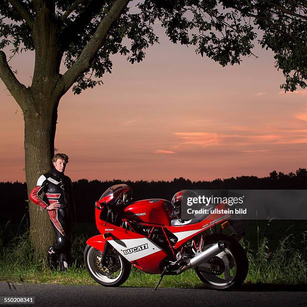 Man looking at his Ducati in the evening light