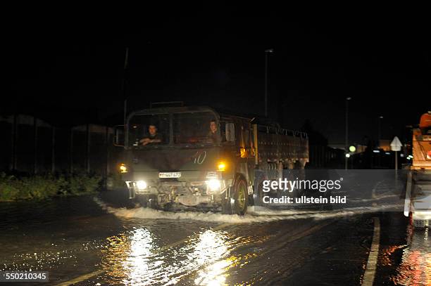 Fahrzeuge der Bundeswehr bahnen sich ihren Weg durch überflutete Strassen am Umspannwerk in Magdeburg-Rothensee