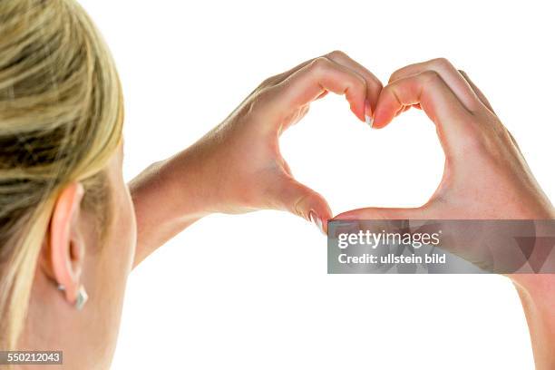 Eine Frau hält ihre Hände in der Form eines Herzen. Symbolfoto für Liebe.