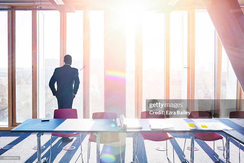 Thoughtful businessman looks out of office window