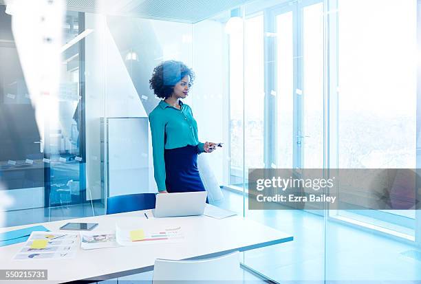 businesswoman checking emails at window - office desk top view stockfoto's en -beelden