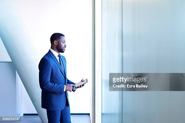 businessman thinking while using tablet - businesswear stock pictures, royalty-free photos & images
