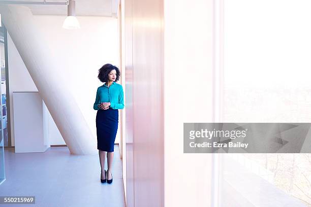 businesswoman thinking as she looks over city - camisa colorida - fotografias e filmes do acervo