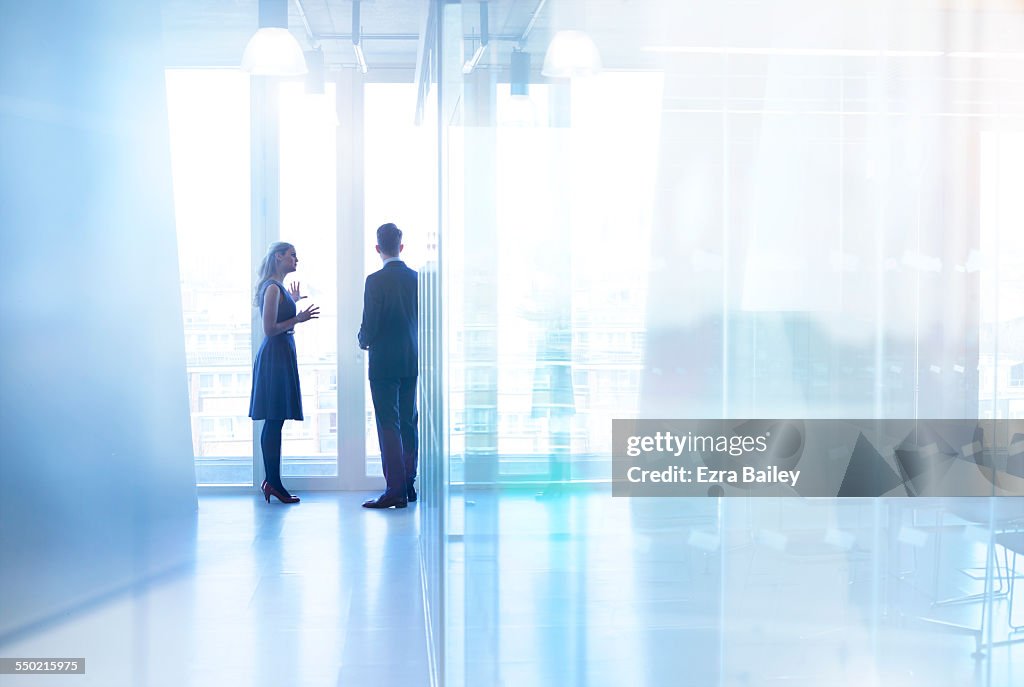 Colleagues standing chatting in modern office