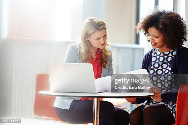 two businesswomen discussing plans - document management stock-fotos und bilder