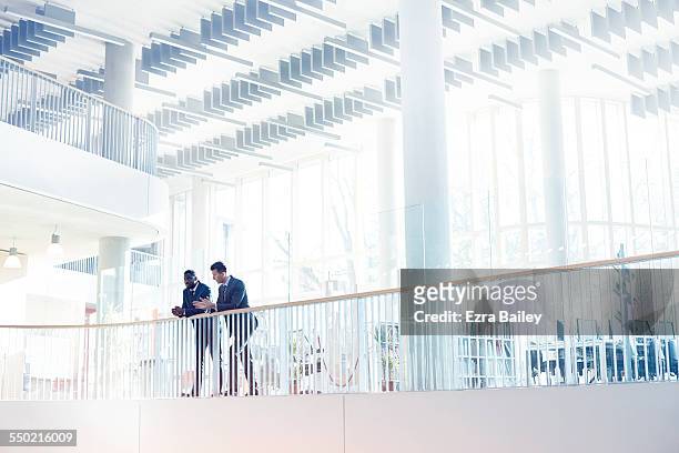 businessmen discussing plans in modern office - parapetto barriera foto e immagini stock