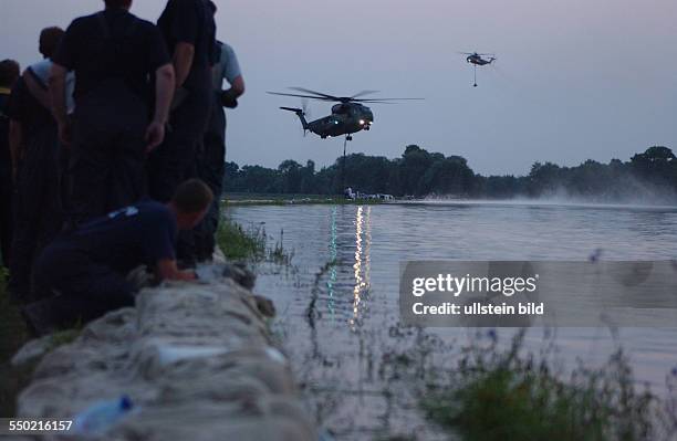 Hubschrauber der Bundeswehr unterstützen sie Sicherung eines Deiches im Dessauer Vorort Mildensee