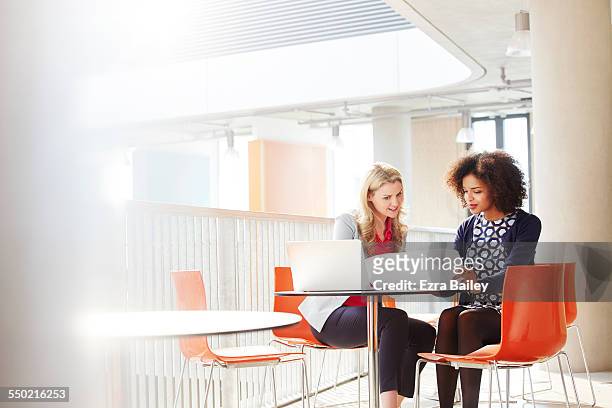 two business women discussing a project. - hablar fotografías e imágenes de stock