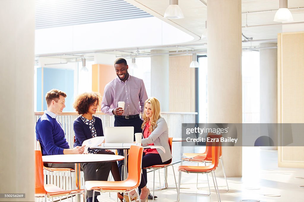 Colleagues discussing project with coffee