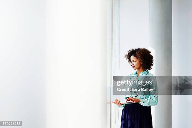 businesswoman with laptop looking out of window. - good laptop stock-fotos und bilder