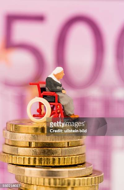 Frau im Rollstuhl auf Geldstapel. Vor Euro-Geldschein