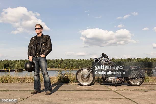 Young man wearing leather clothes with his Harley Davidson