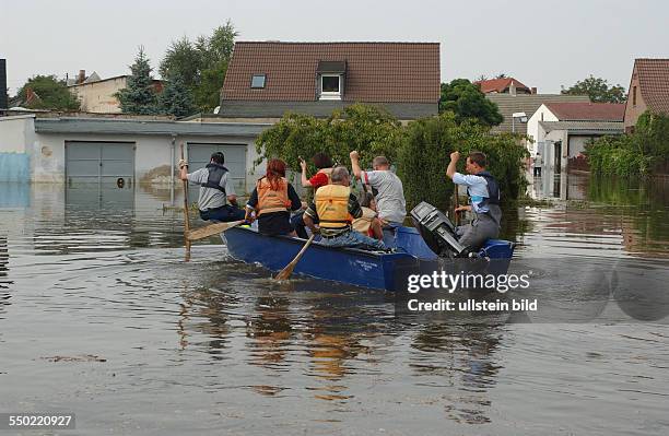 Mitarbeiter des THW setzen Anwohner der Örtchens Gübs mit einem Boot über