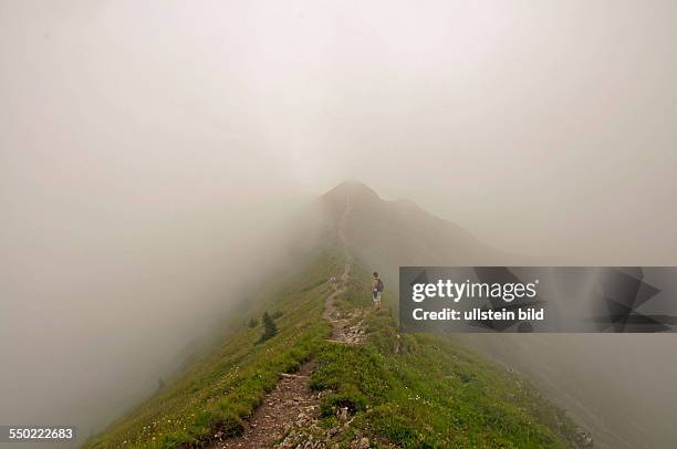 Hiking trail in the fog horn from the Fellhorn to the Soellereck, Allgäu Alps, Bavaria, Germany .