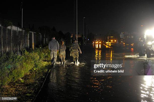 Soldaten der Bundeswehr waten durch das Wasser auf dem Weg zum Umspannwerk in Magdeburg-Rothensee
