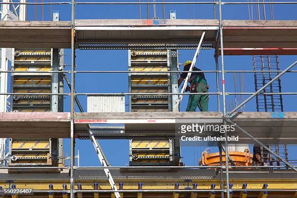 Construction workers on scaffolding. Reinforcement work on the construction site of a commercial building in downtown Bonn