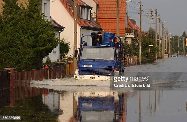 Fahrzeug des Technischen Hilfswerkes fährt durch eine überschwemmte Straße von Waldersee
