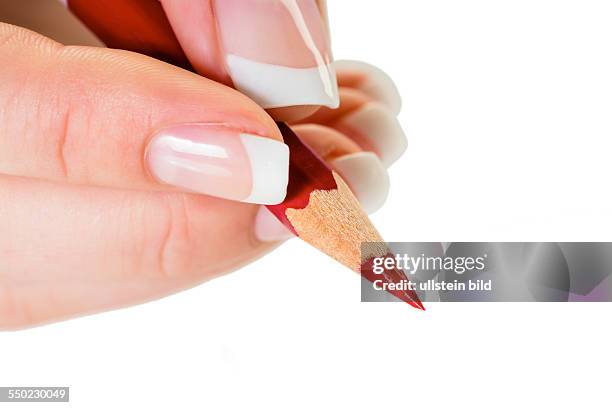 Eine Hand hält einen roten Stift. Symbolfoto für Einsparungen und Budegt Kürzungen.
