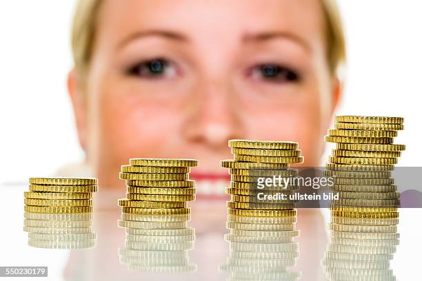 Eine Frau stapelt Münzen. Geld sparen für die Zukunft.