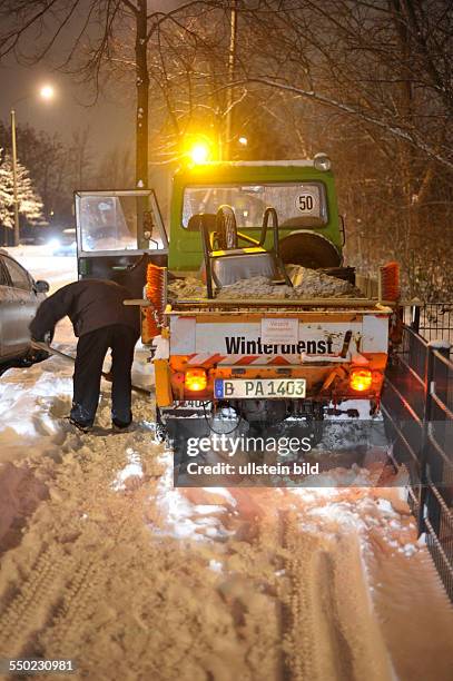 Winter in Berlin - Mitarbeiter eines privaten Winterdienstes versucht sein Fahrzeug in der Storkower Strasse aus dem Schnee zu befreien