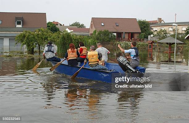 Mitarbeiter des THW setzen Anwohner der Örtchens Gübs mit einem Boot über