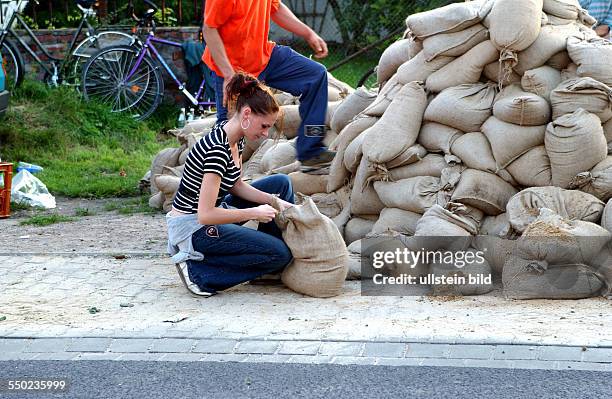 Freiwillige Helfer füllen Sandsäcke in Magdeburg
