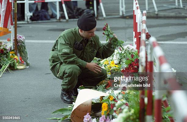 Polizist legt Blumen an der US-Botschaft in Berlin am Tag nach den Terroranschlägen in den USA nieder