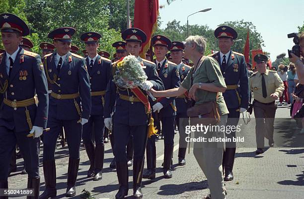 Abschiedsparade der russischen Streitkräfte in Berlin Schöneweide - eine Frau überreicht den Soldaten Blumen