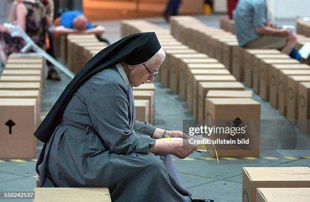 Einsame Nonne sitzt auf einem Pappkarton anlässlich des Ökumenischen Kirchentages in Berlin