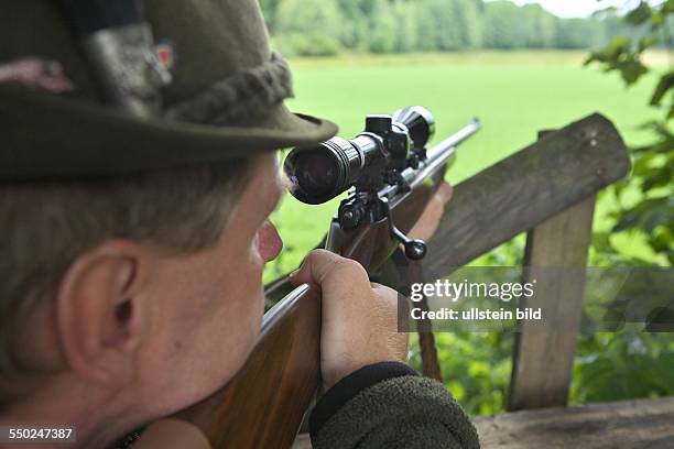 Hunter with rifle on his high seat