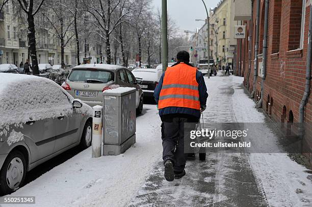 Wintereinbruch in Berlin - Winterdienst befreit den Bürgersteig in der Wichertstrasse in Berlin-Prenzlauer Berg vom Schnee, Räumdienst