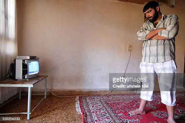 April 27 Yabrud, Rif Dimashq, Syria. A man is watching the news on the current situation in Damascus from inside the family home which has been hit...