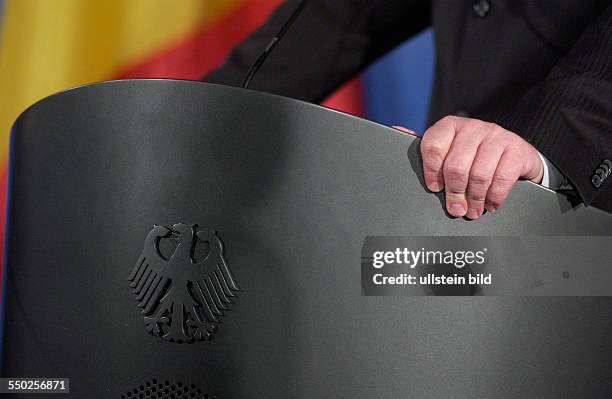 Bundesaußenminister Frank-Walter Steinmeier hält sich an seinem Rednerpult fest bei einer Pressekonferenz in Berlin