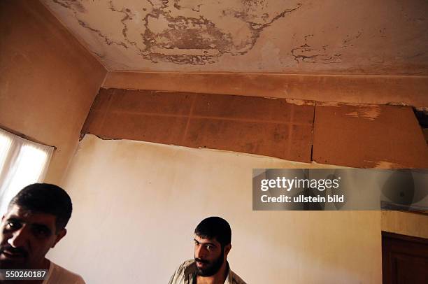 April 27 Yabrud, Rif Dimashq, Syria. A father and his younger brother are inside the family home which has been hit the night before by tank shells....