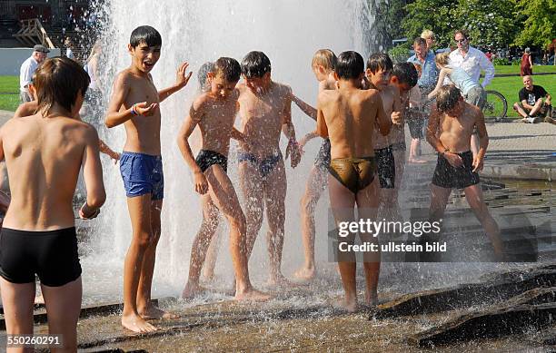 Sommerhitze in Berlin - Jugendliche verschaffen sich eine Abkühlung in einem Springbrunnen am Berliner Lustgarten