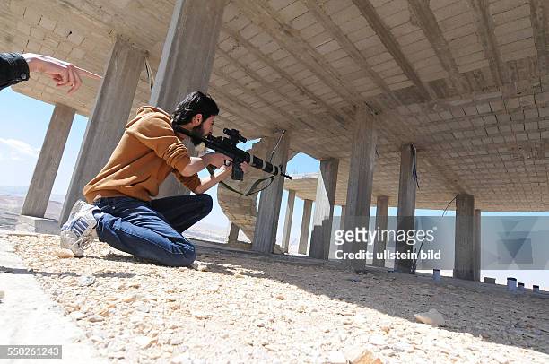 April 25 Yabrud, Rif Dimashq, Syria: An FSA fighter is taking aim at government troops controlling the next town over, Al Nabk. Situated 80KM North...