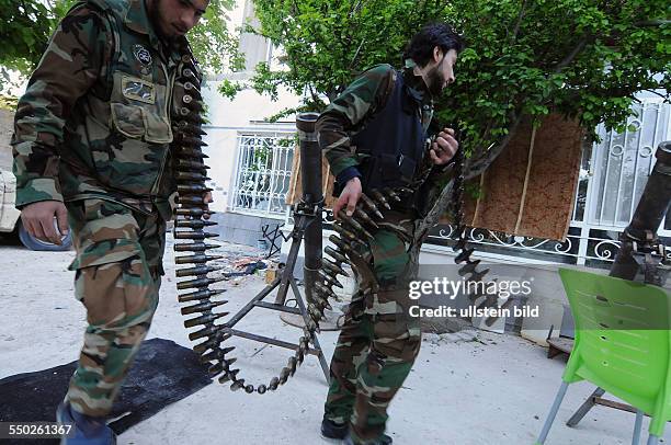 April 27 Yabrud, Rif Dimashq, Syria. Members of an Al Faruk Katiba are carrying away 40mm rounds used against government jet fighters who have been...