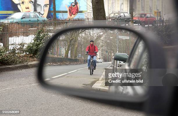 Radfahrer im Rückspiegel eines Autos