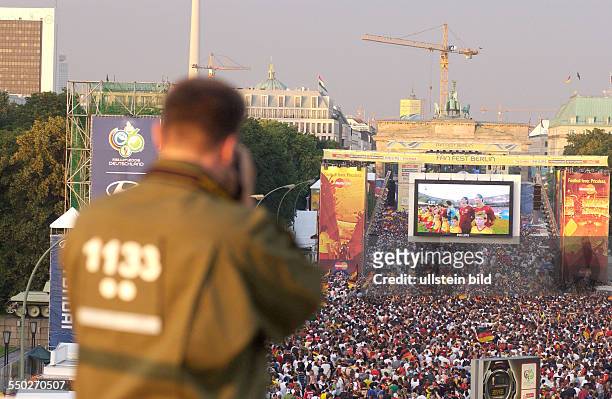 Polizist beobachtet das Fan Fest FIFA-WM 2006 am Brandenburger Tor in Berlin während des Spiels Deutschland-Portugal