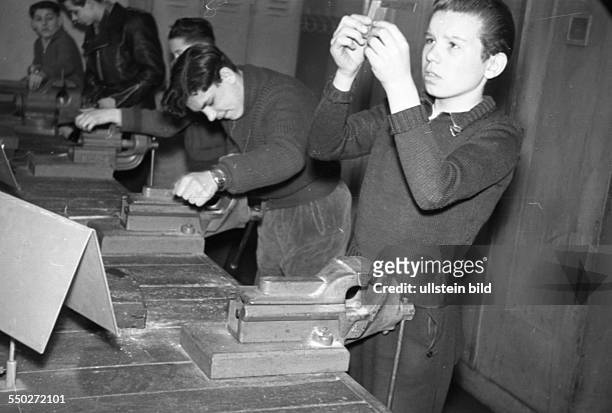 Adolescents working in the metalworking shop, working with the file