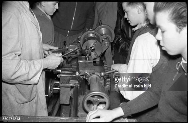 Adolescents working in the metalworking shop, working at the engine lathe