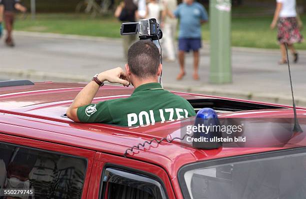 Polizist beobachtet mit einer Videokamera die Demonstration gegen den israelischen Militärschlag gegen die Hisbollah im Libanon in Berlin