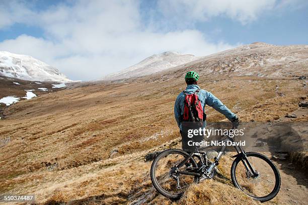 a mountain biker stops to look at a beautiful mountain view - look back 個照片及圖片檔