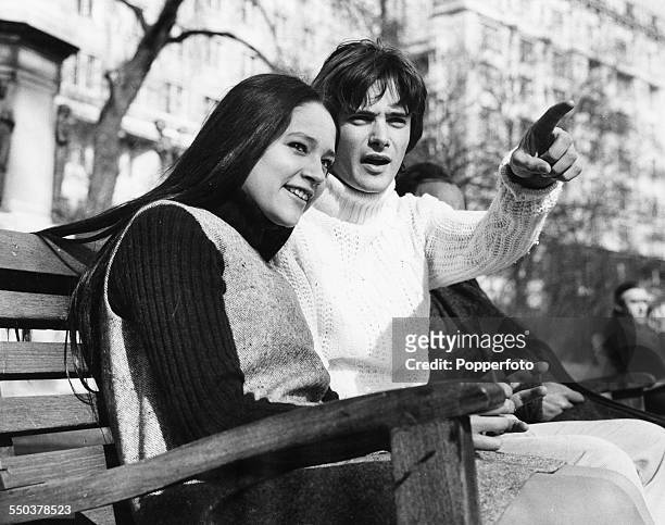 Actors Leonard Whiting and Olivia Hussey, stars of the new Zeffirelli film 'Romeo and Juliet', chatting on a park bench, London, March 6th 1968.