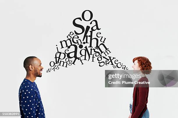 man and woman with illustrated jumble of letters - languages stock pictures, royalty-free photos & images
