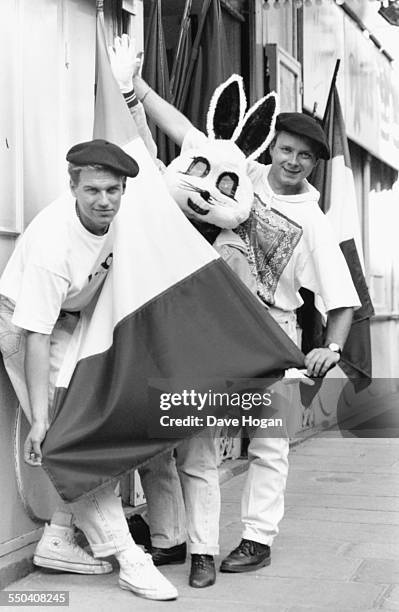 Pop band 'Jive Bunny and the Mastermixers' wearing beret's and holding French flags as they pose with someone in a bunny costume, Paris, circa 1985.