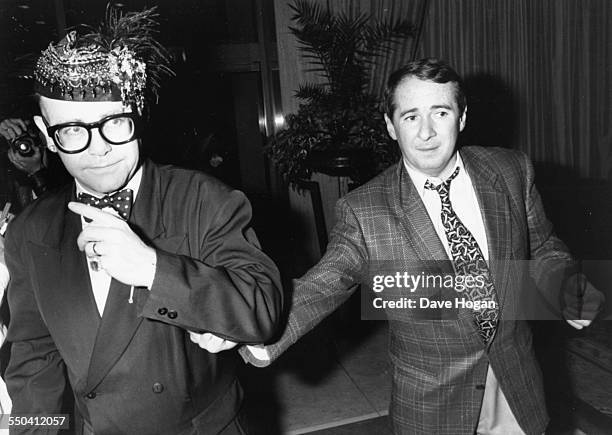 Musician Elton John and music manager John Reid attending a party held by Whitney Houston in London, May 16th 1988.